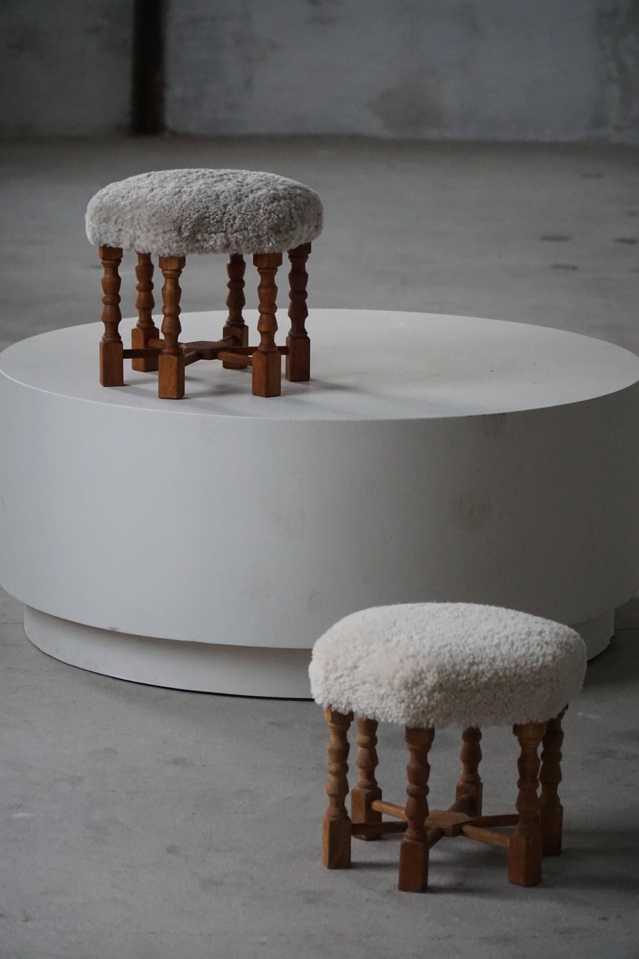 Pair of mid-century Danish oak stools with shearling lambswool upholstery, 1950s.
