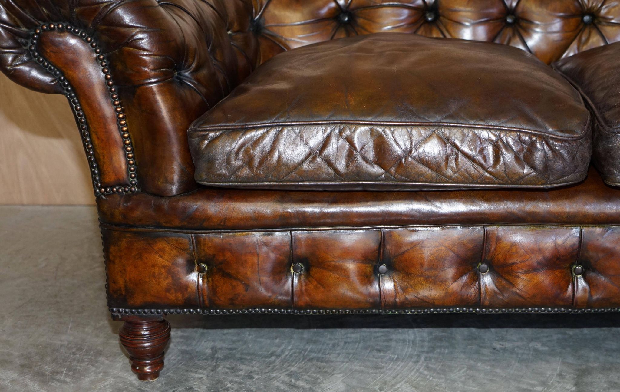 Victorian Chesterfield leather upholstered canapé with feather cushions.