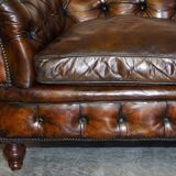 Victorian Chesterfield leather upholstered canapé with feather cushions.