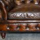 Victorian Chesterfield leather upholstered canapé with feather cushions.