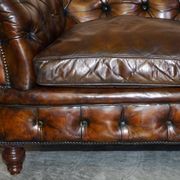 Victorian Chesterfield leather upholstered canapé with feather cushions.