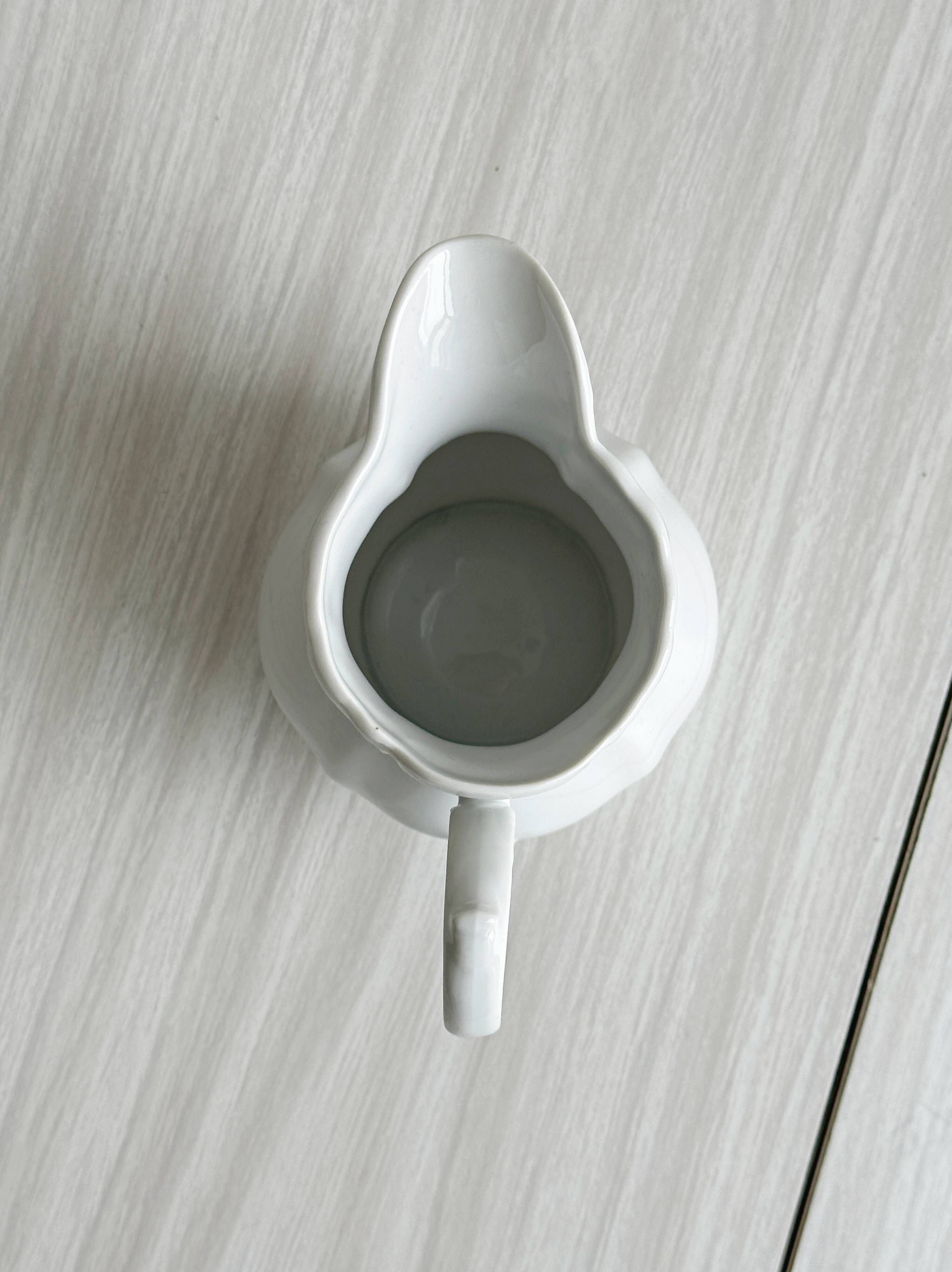 Old white porcelain milk jug, cream jug with relief.