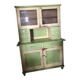 Vintage wooden kitchen cupboard painted green and beige, with glass doors - 1930s