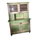 Vintage wooden kitchen cupboard painted green and beige, with glass doors - 1930s