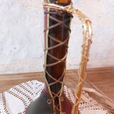 Amber bottle covered in colored leather with handle surrounded by wire, vintage