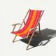 Vintage deck chair with red and orange striped fabric, original patina.