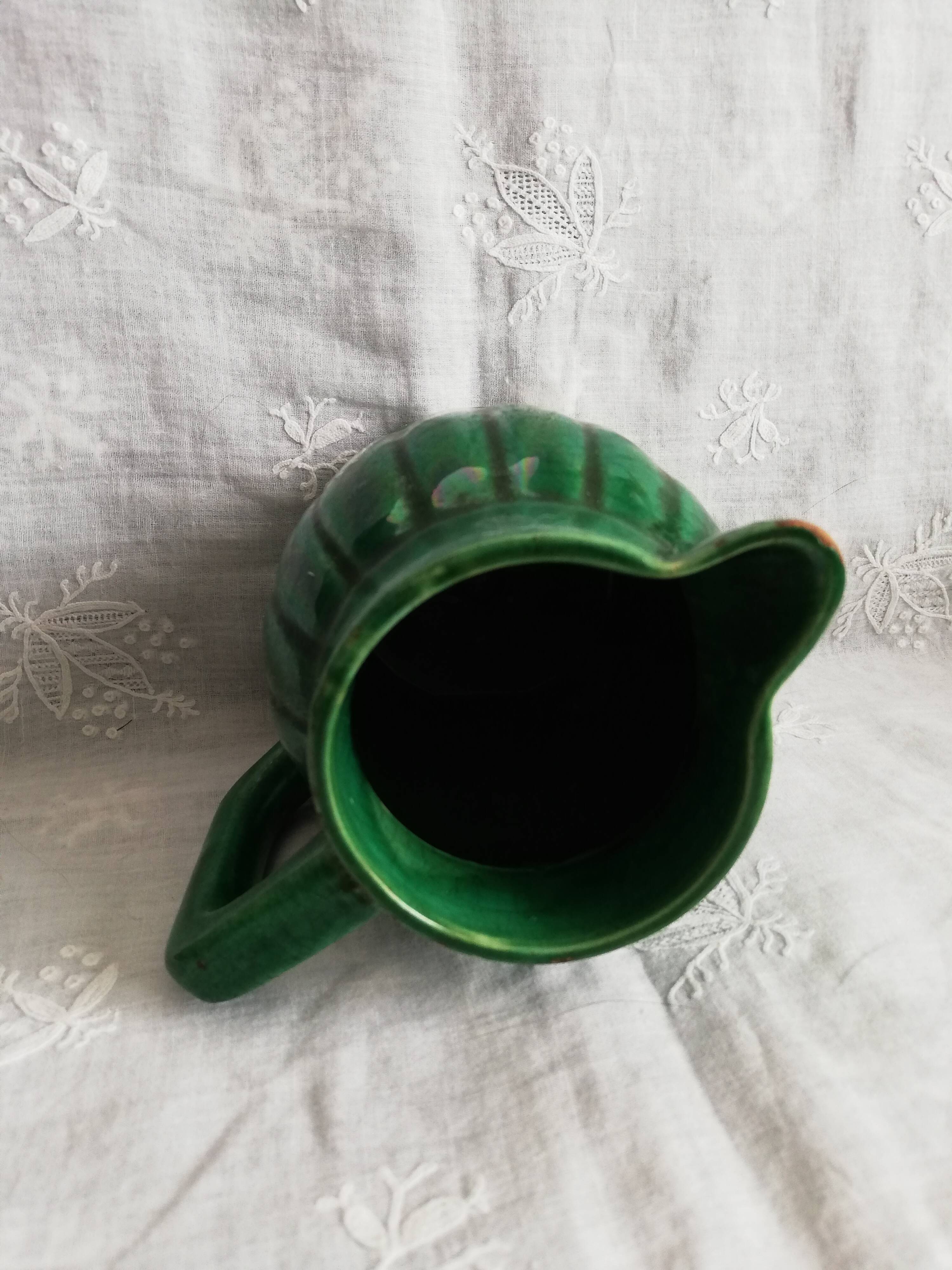 Old green pitcher in dabbling