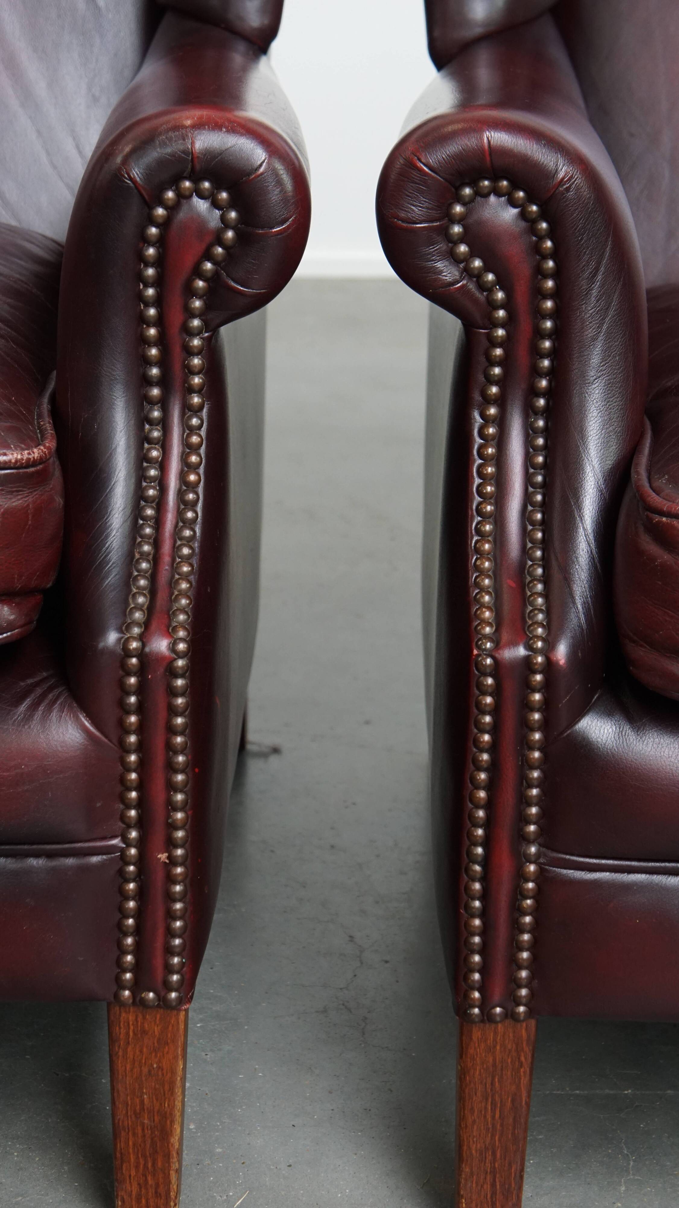 Ensemble de 2 fauteuils à oreilles en cuir de vachette + pouf de style anglais