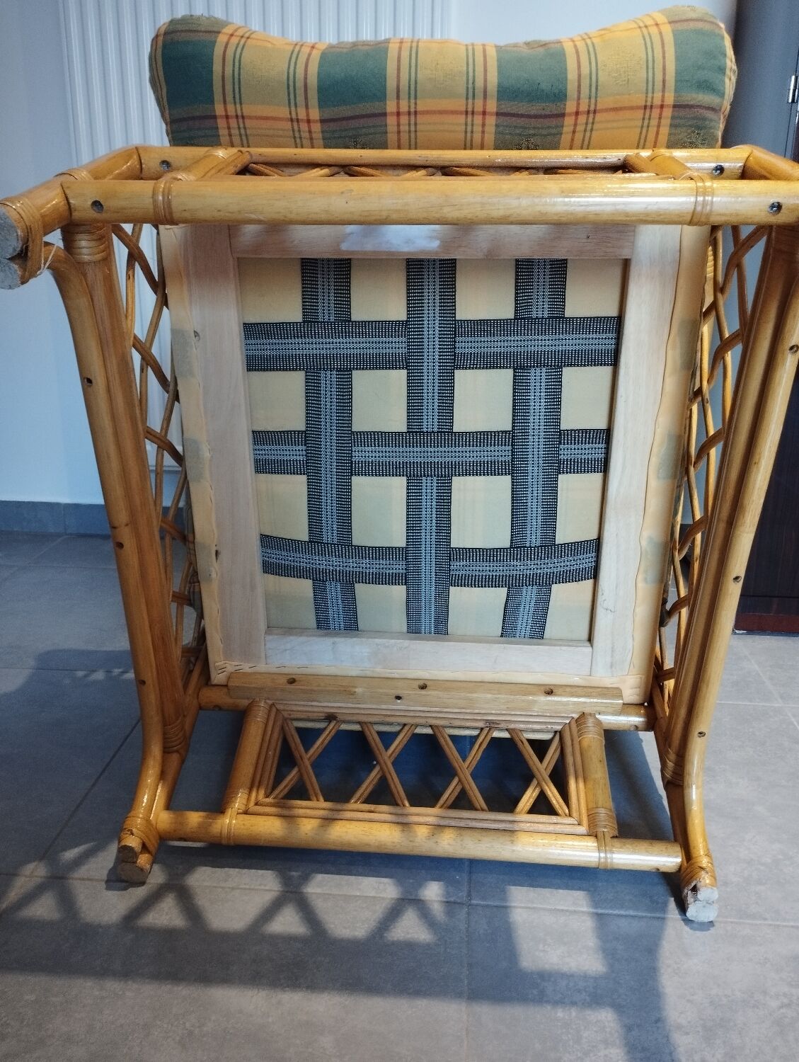 Vintage armchair in bamboo and rattan with a tartan pattern.