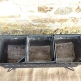 Black perforated metal planter from the 1950s