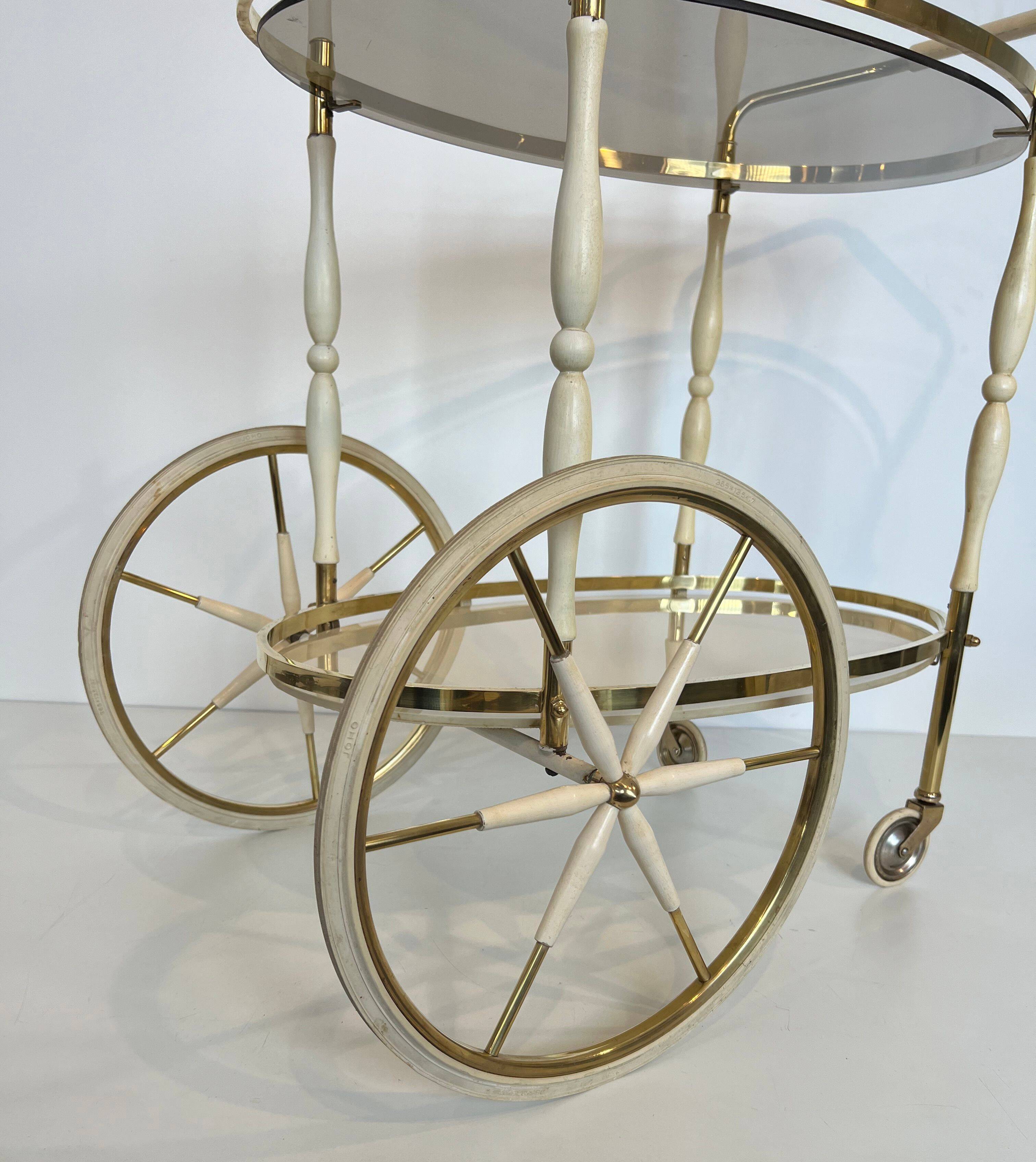 Italian oval rolling table in brass and lacquered wood.