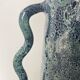 Blue-green ceramic vase with abstract wavy handles