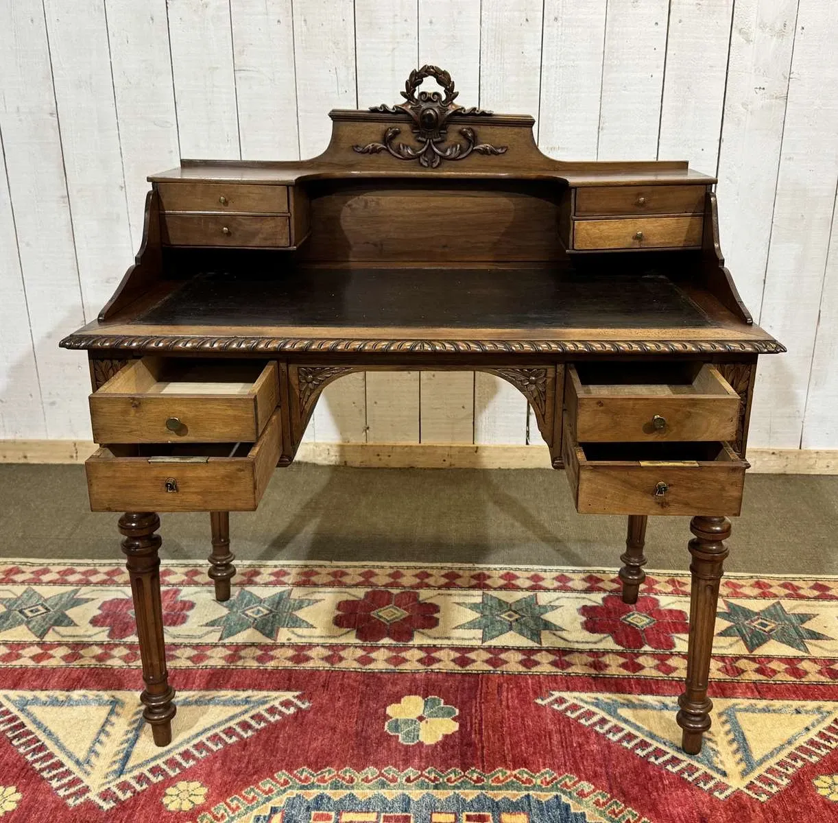 Louis XVI style desk from the late 19th century in walnut with a leather top.