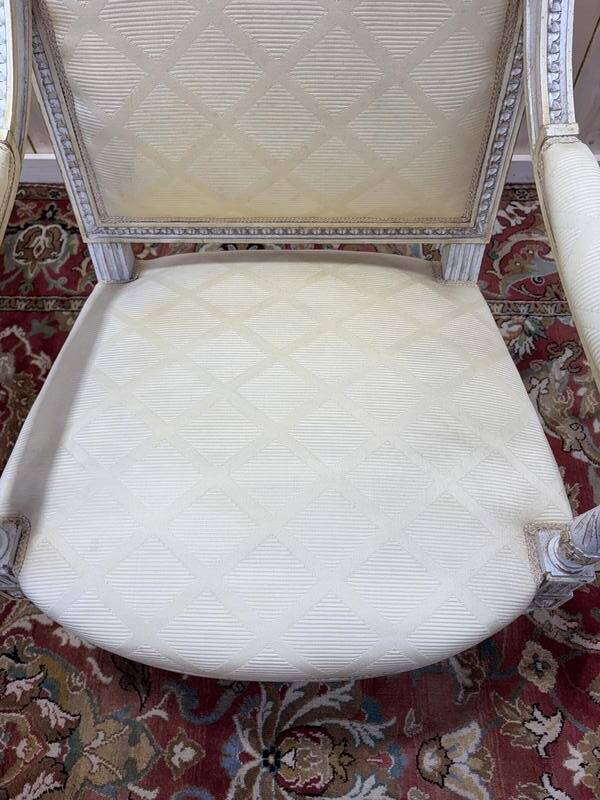 Paire de fauteuils de style Louis XVI en bois patiné