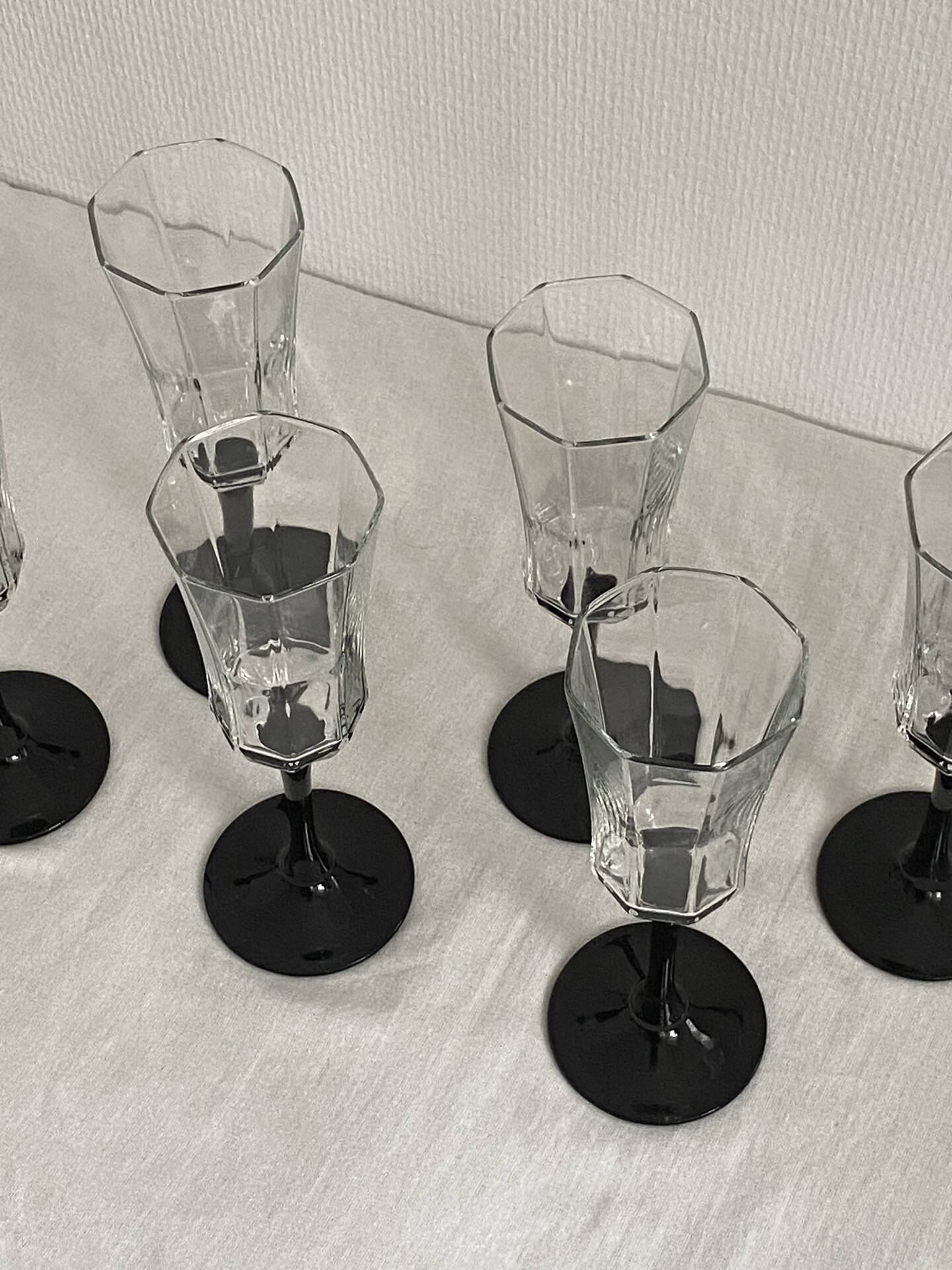 Set of 6 Octime champagne flutes in glass with black stem.