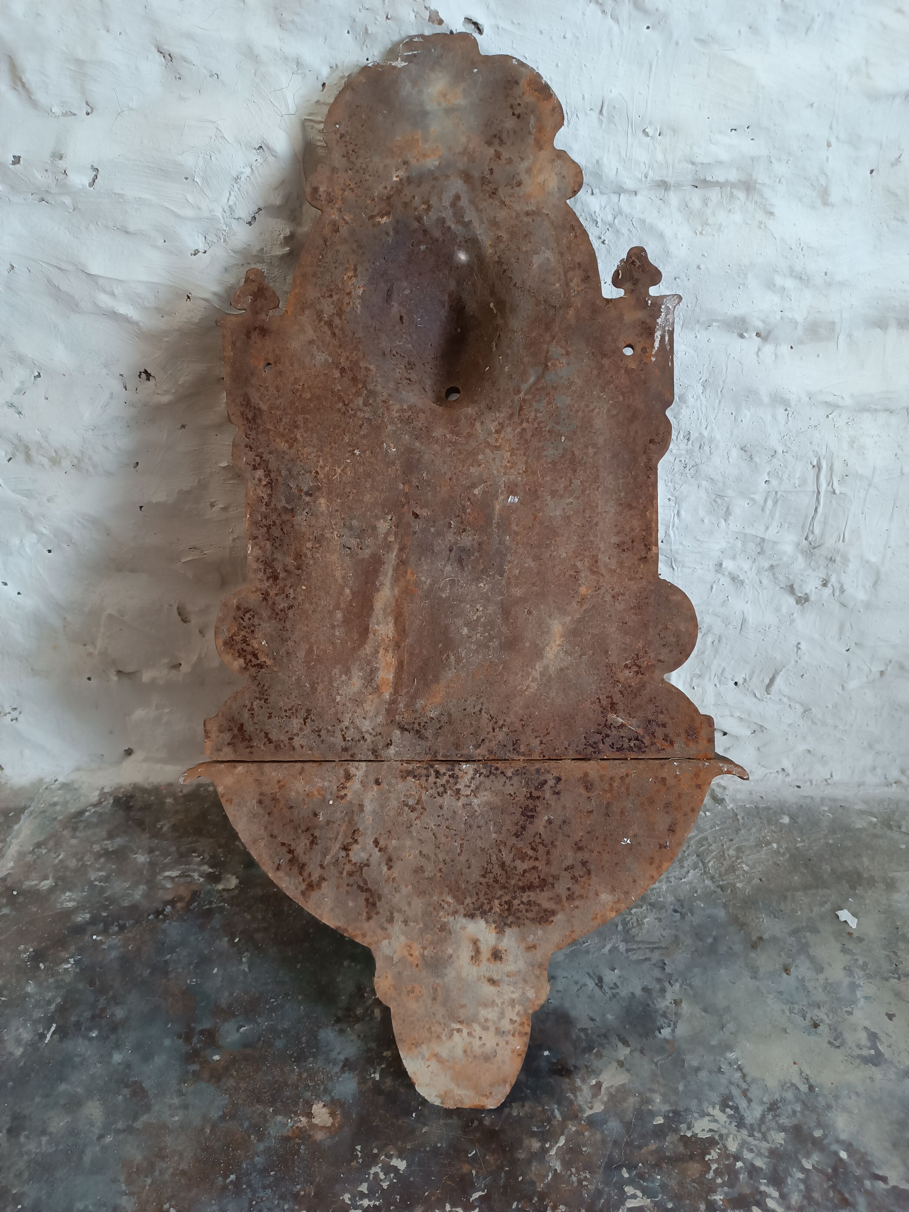 Old cast iron wall fountain with lion's head
