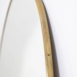 Oval shaped mirror set with a gilded brass rod. 1970s.