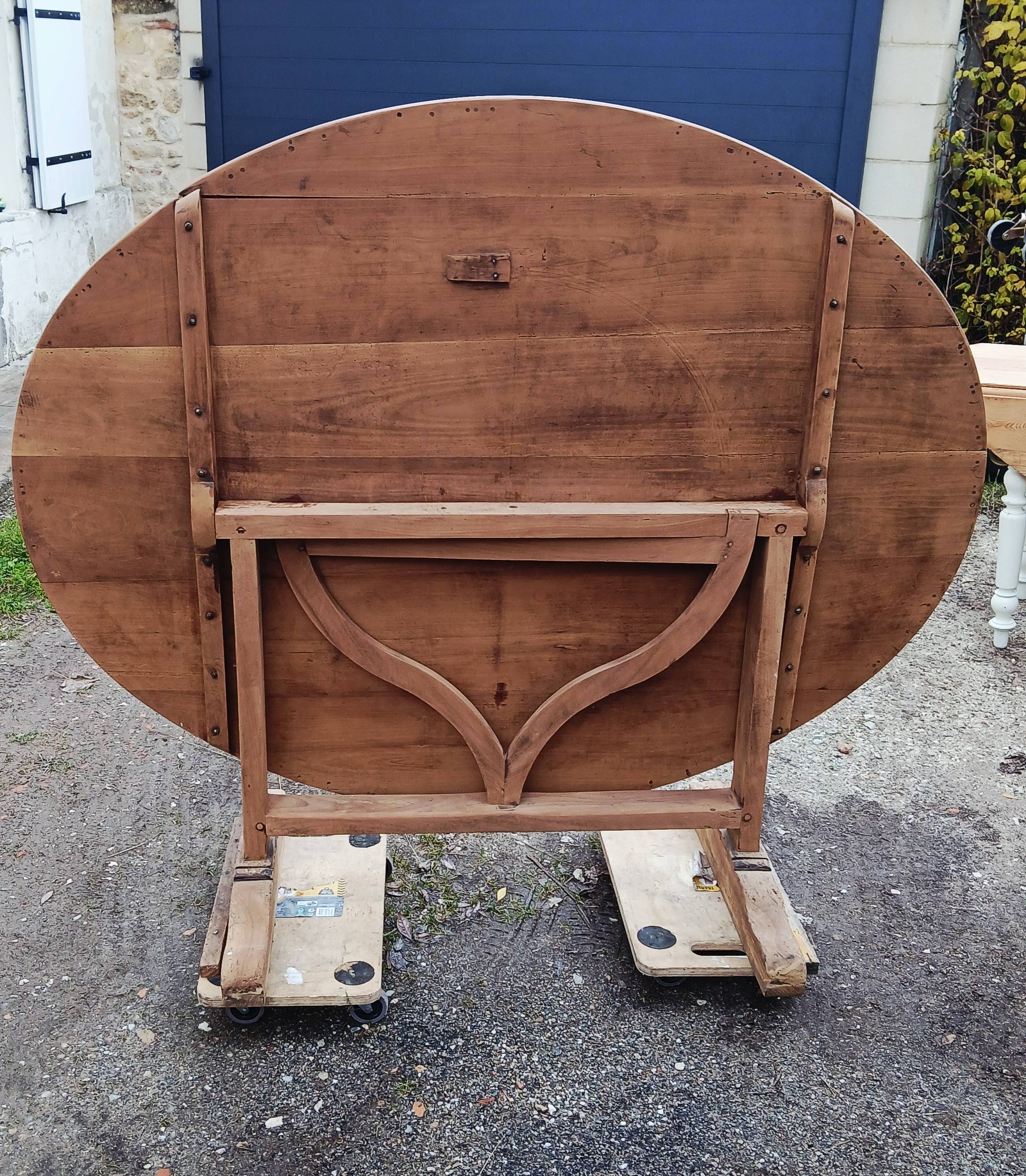 Oval table of grape harvesters from the Southwest in cherry wood