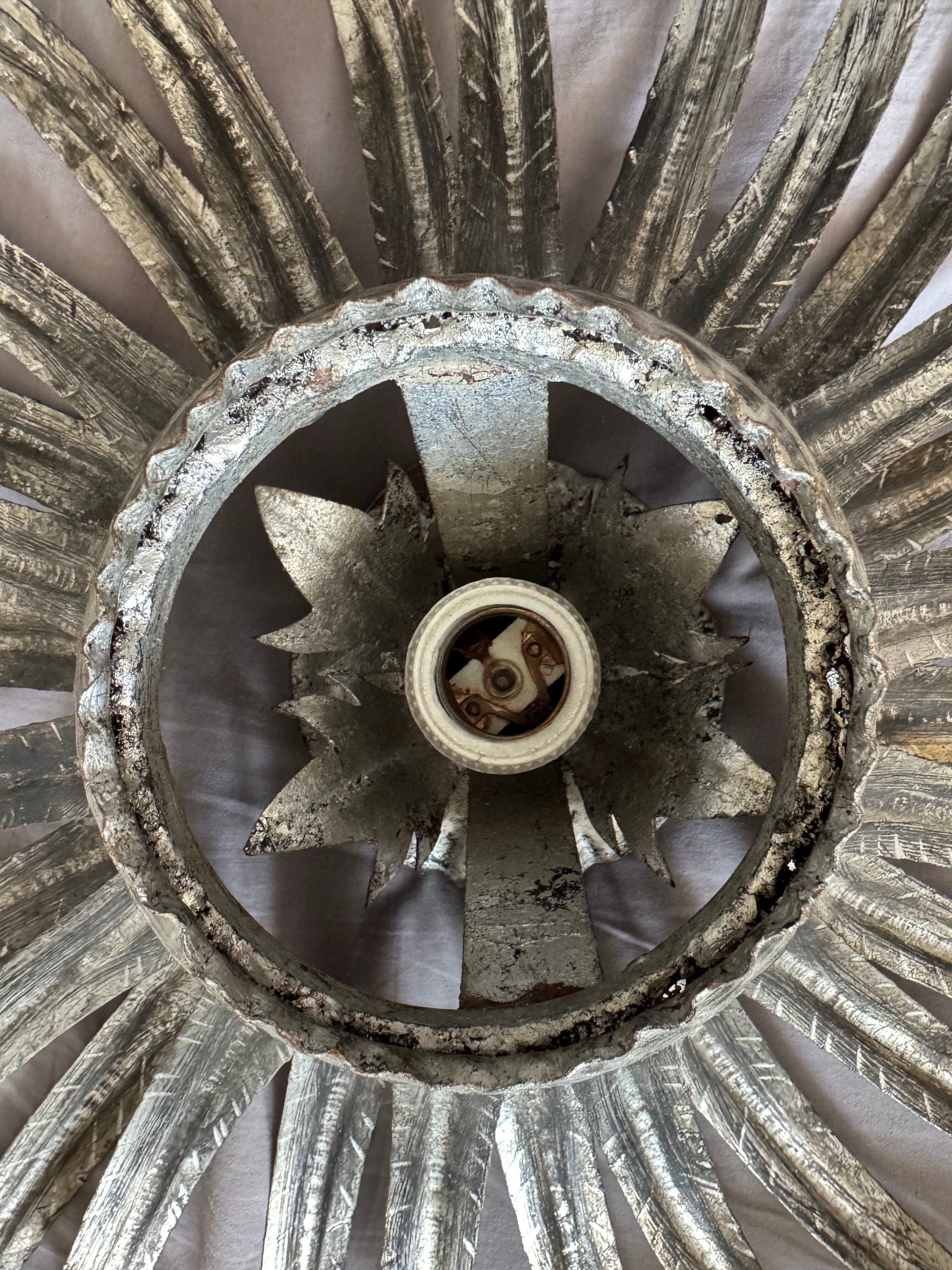 Silver wrought iron sunburst wall light from the 1960s.