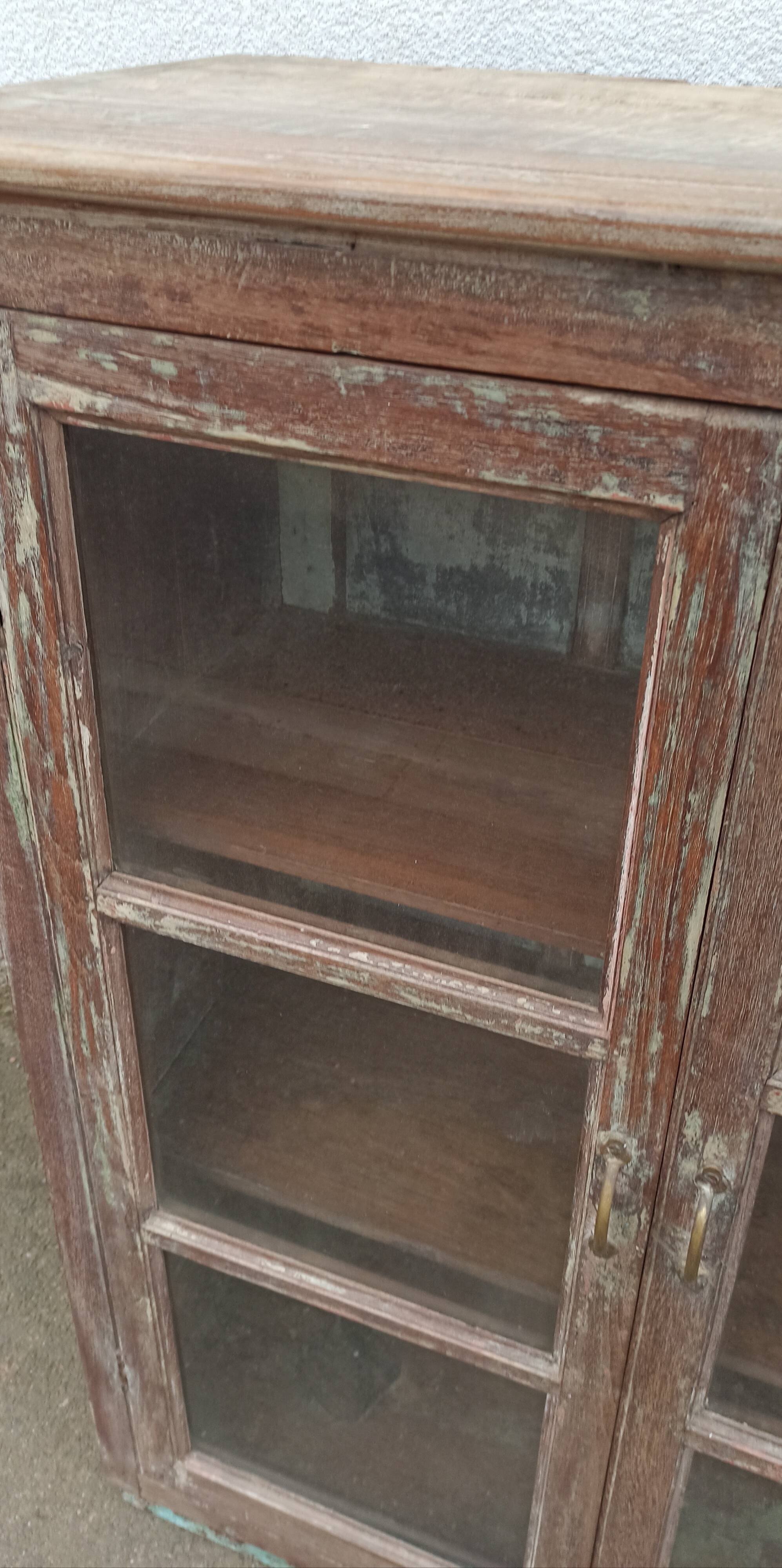 Old glazed wooden cabinet with metal bottom