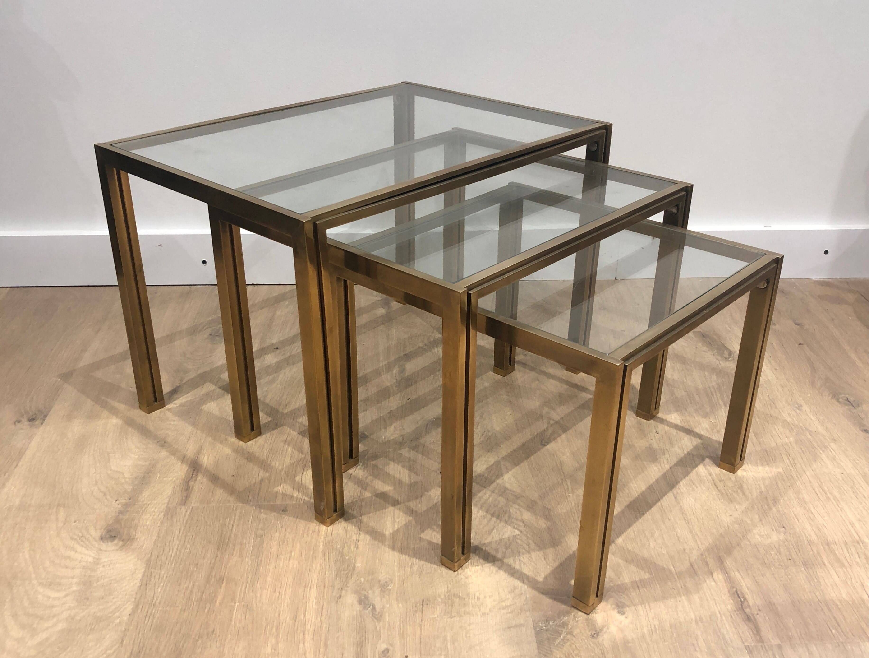 Set of 3 nesting tables in brass and glass. French work by Guy Lef.