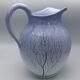 Blue glazed terracotta pitcher with hand-painted decoration, signed