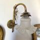 Antique brass wall light with glass shade.