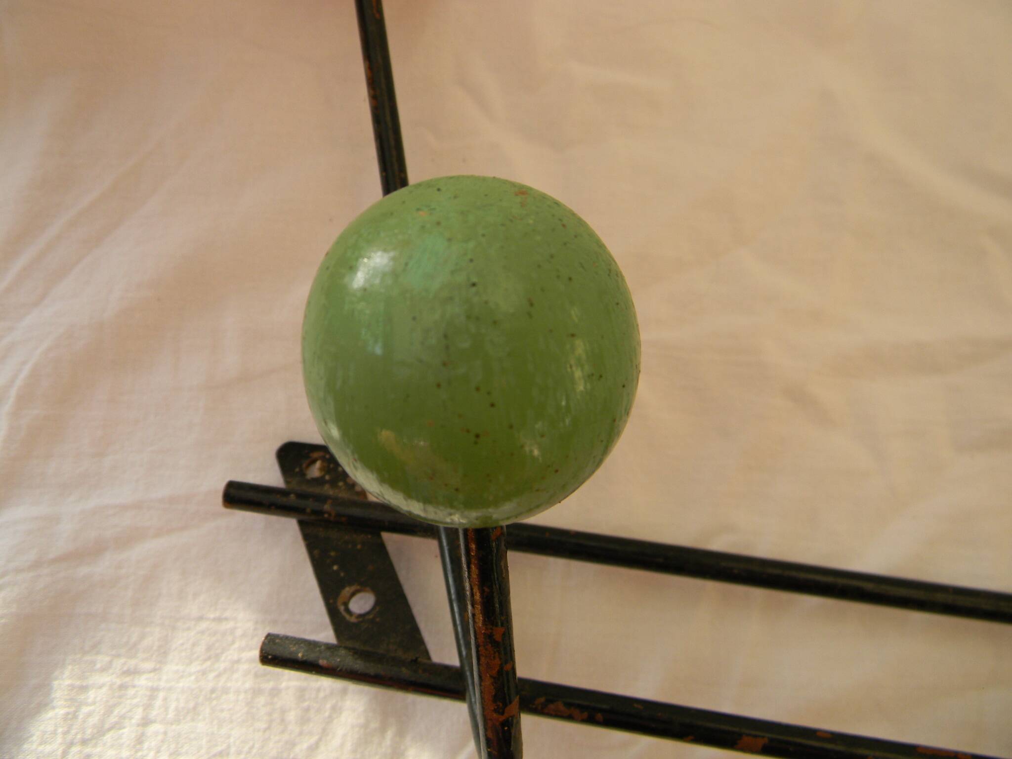 Small wrought iron coat rack with wooden balls.