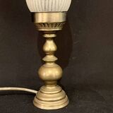 Old bronze or brass table lamp from the early 20th century with white streaked flame glass globe