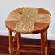 Antique wooden bar stool with a straw seat