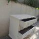 A beautifully crafted crossbow-shaped chest of drawers, finished in pearl grey with a whitewashed top.