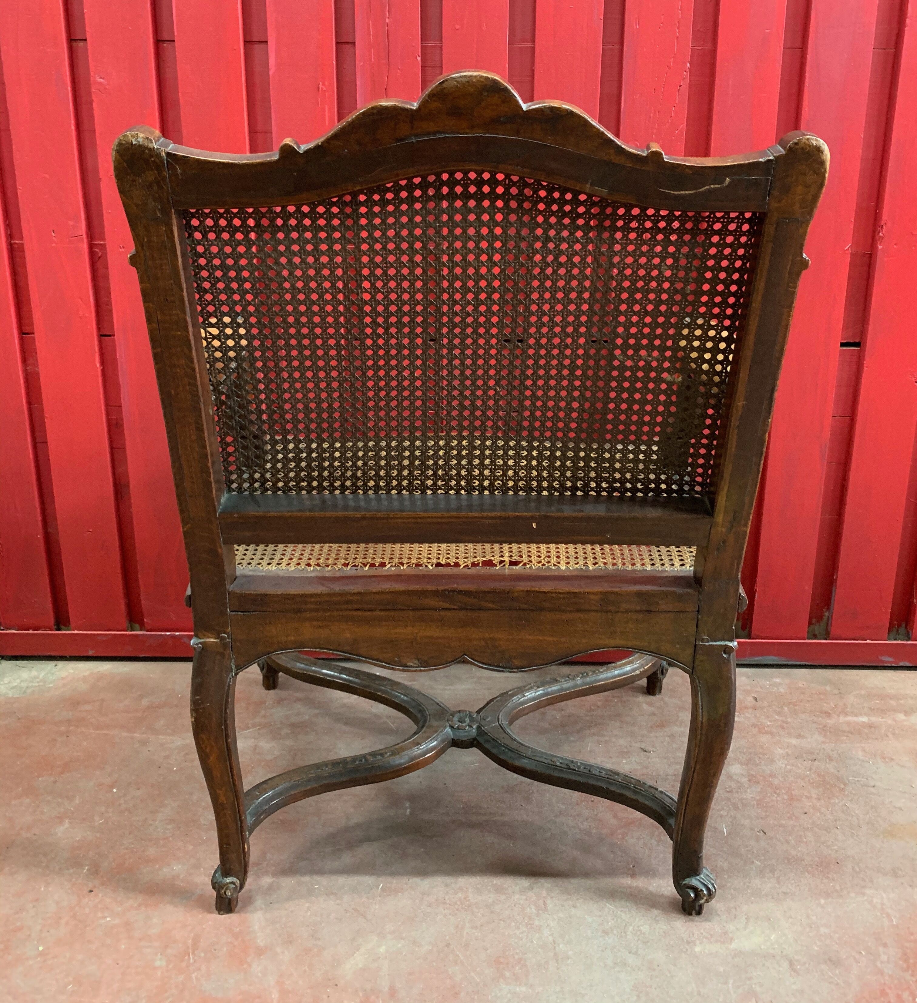 Fauteuil en noyer à fond de canne d'époque Régence début XVIIIème siècle