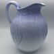 Blue glazed terracotta pitcher with hand-painted decoration, signed