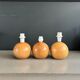 Three wooden ball-shaped lamp stands in light wood.