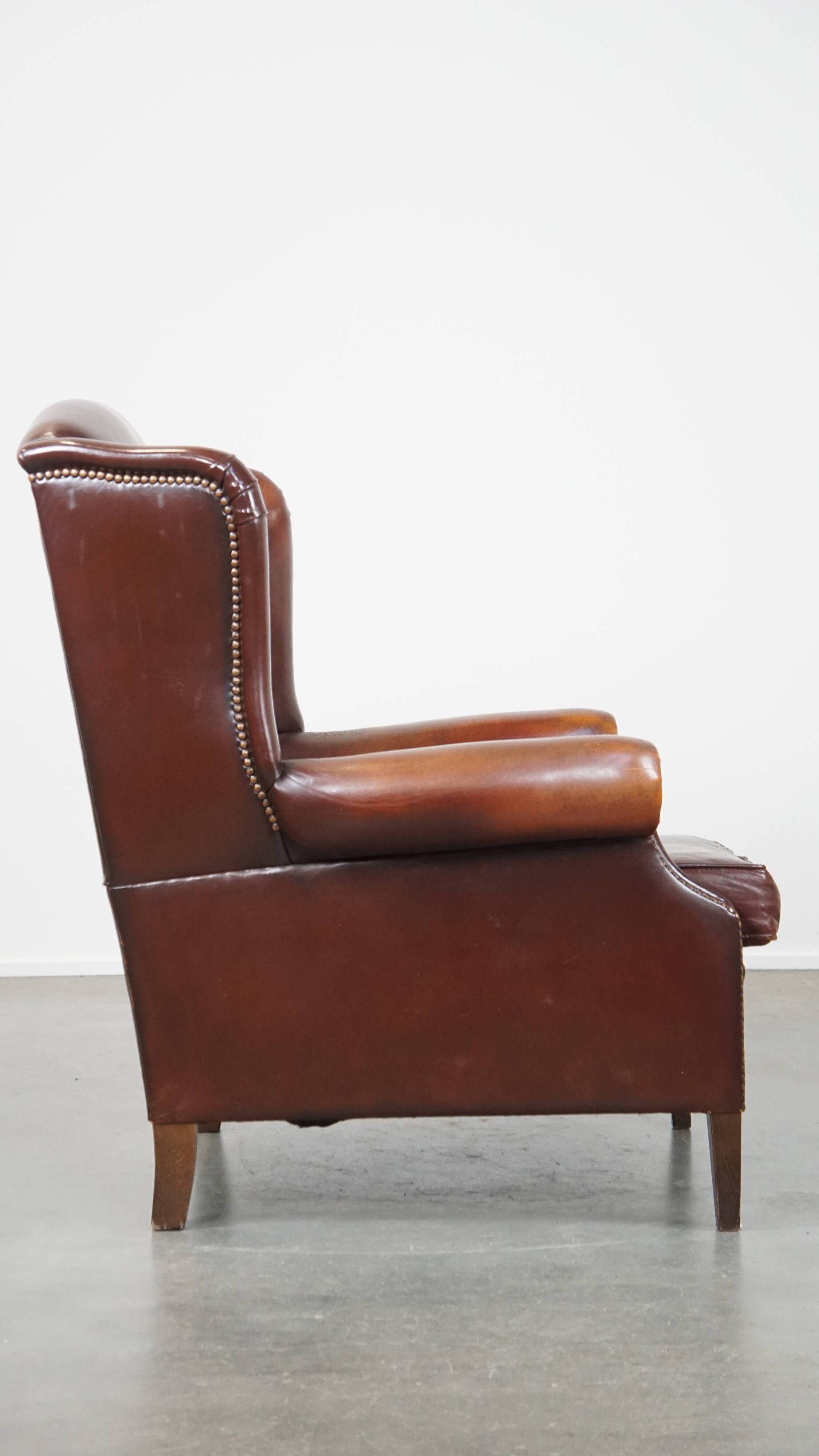 Dark English style sheepskin wingback chair with character and patina