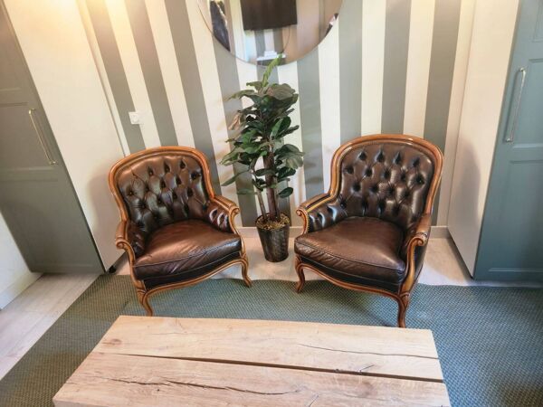 Paire de fauteuils club Chesterfield anciens en cuir brun capitonné –