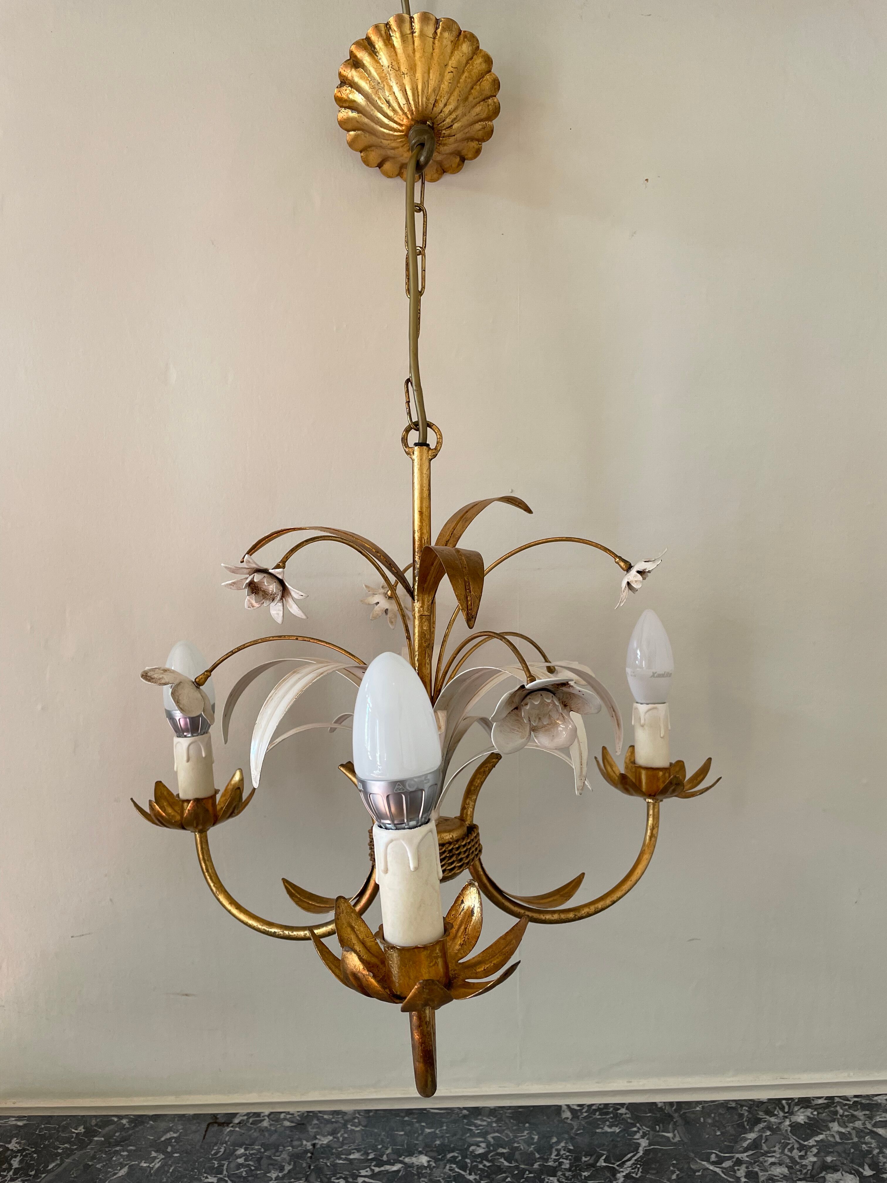 Golden metal chandelier decorated with flowers