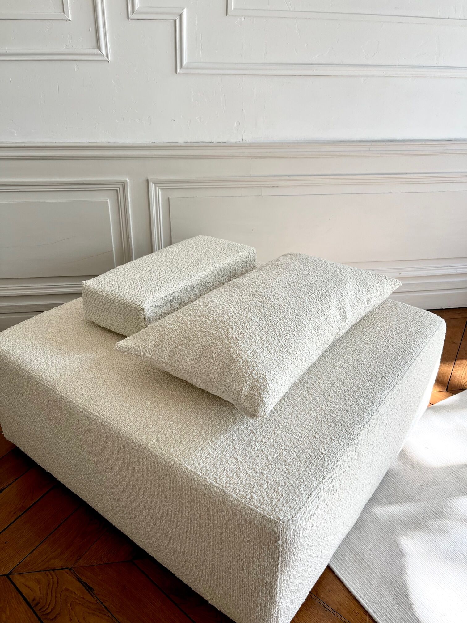 Square ottoman and its cushions in buckle fabric