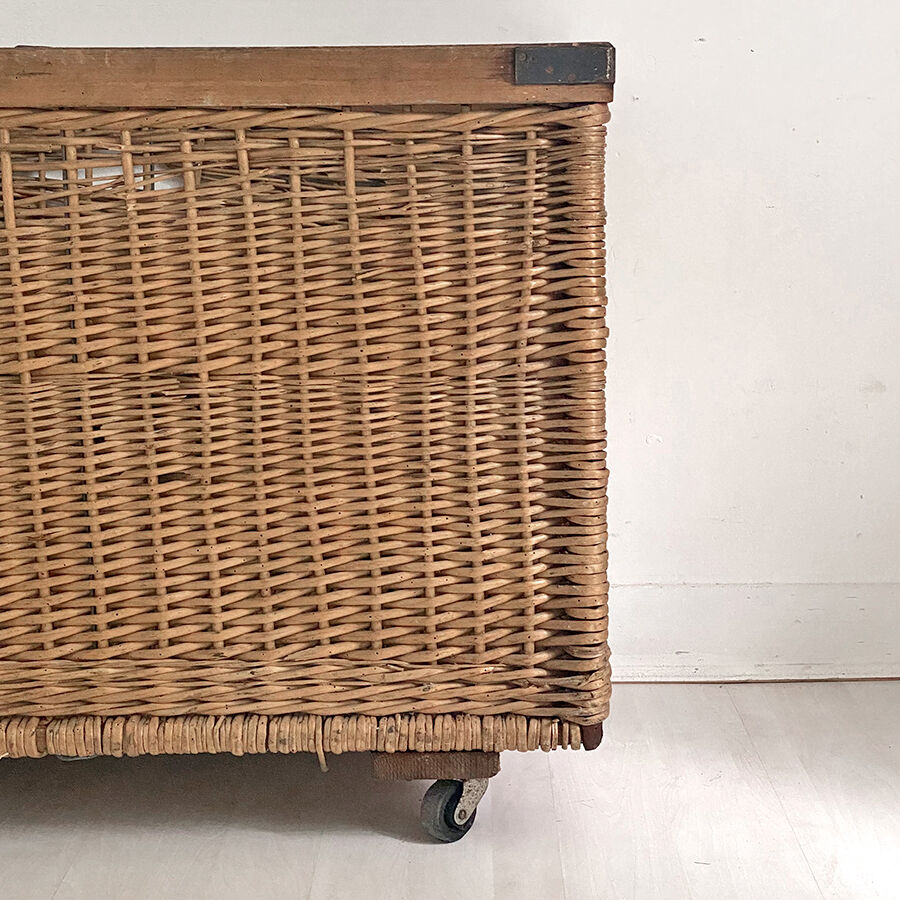 Old large wicker laundry basket on wheels