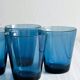 Four small translucent blue glasses.