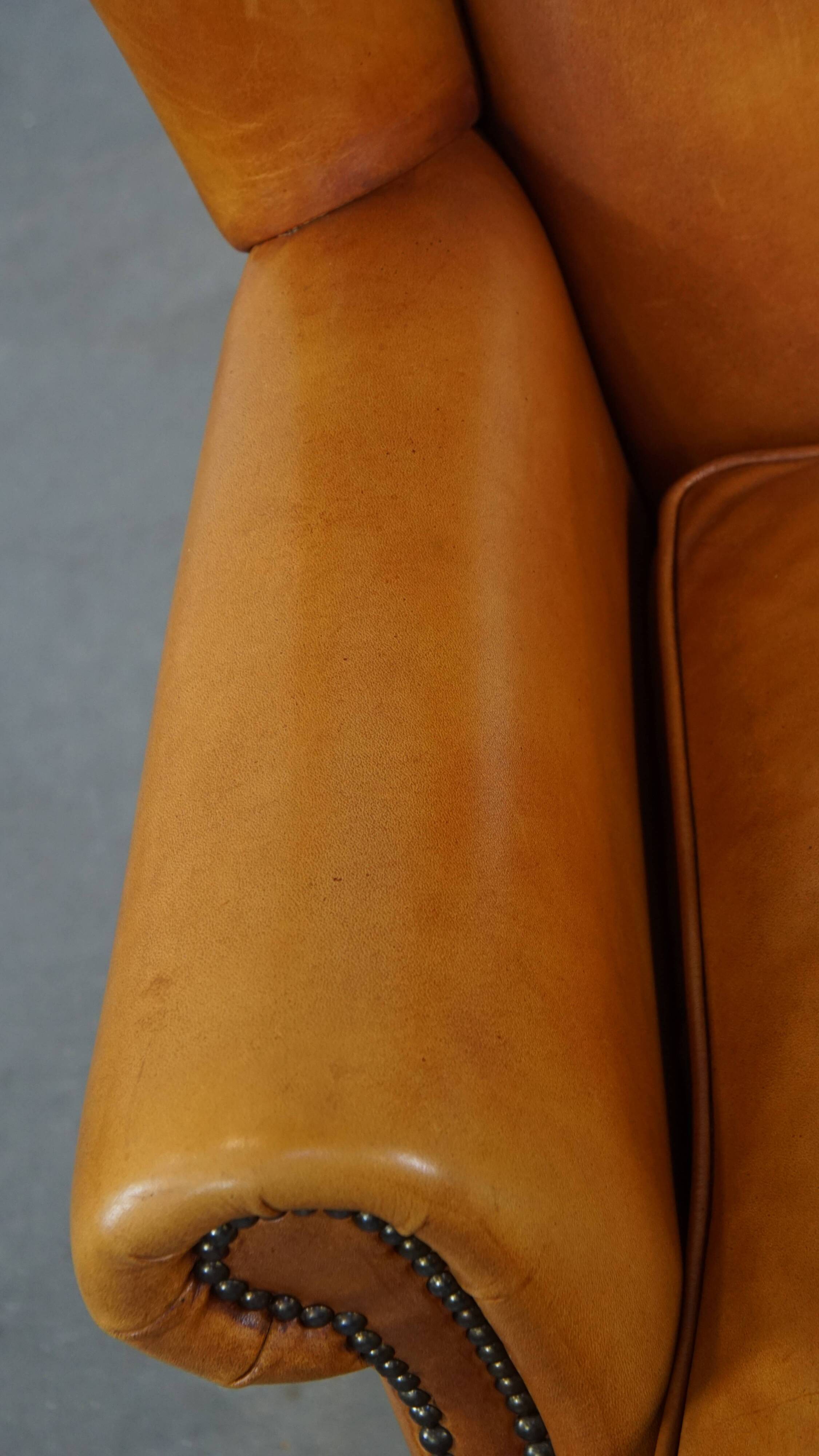 Cow leather wingback chair finished with decorative nails