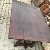 19th-century brown walnut dining table with sculpted trestle legs.