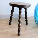 Small wooden tripod stool with turned legs, country style.
