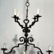 Two-tiered wrought iron chandelier with eight light arms in Gothic style.