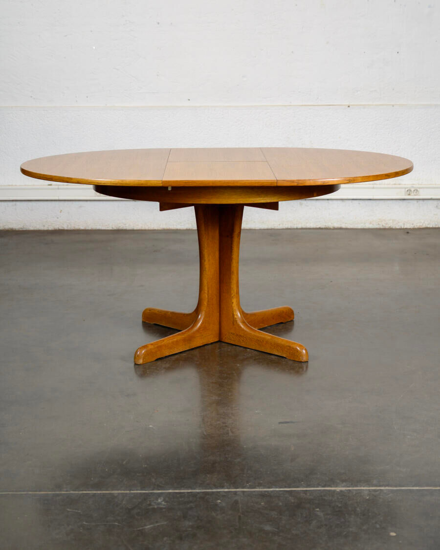 Round teak table with an extension.