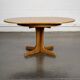 Round teak table with an extension.