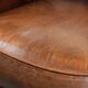 Fauteuil club en cuir de peau de mouton avec un coussin de siège fixe.