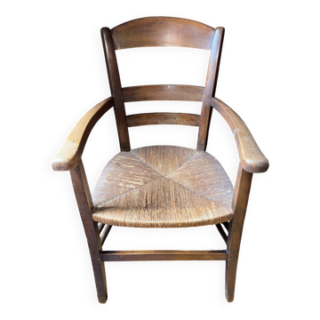 Old rustic armchair in solid wood – seat in plant fibres.