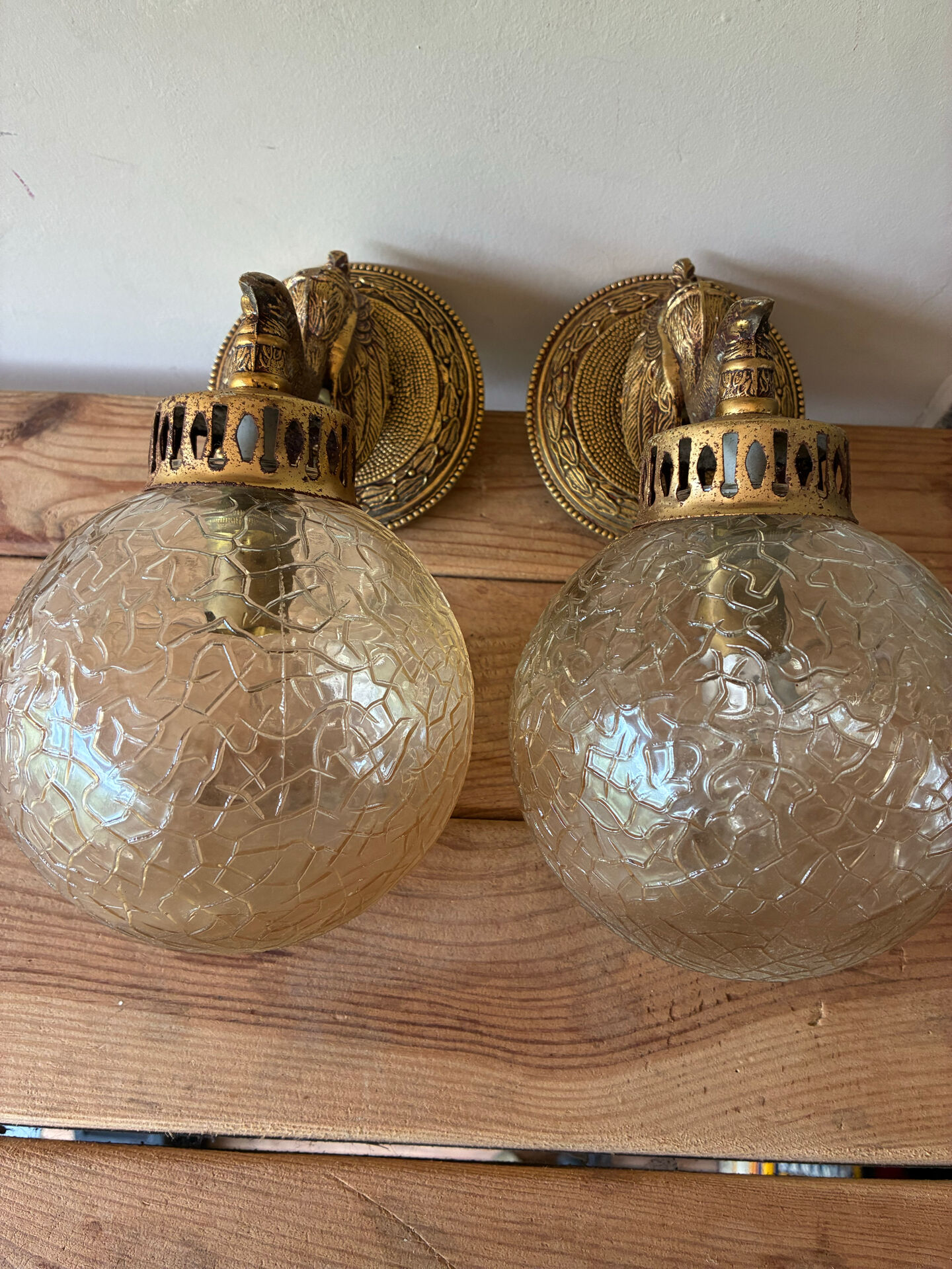 Pair of vintage wall sconces with golden metal swan heads and glass.