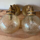Pair of vintage wall sconces with golden metal swan heads and glass.